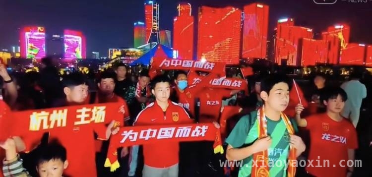 光影交织中，杭州球迷全力为国足中澳之战加油，杭城球迷热情似火，为国足中澳生死战摇旗呐喊